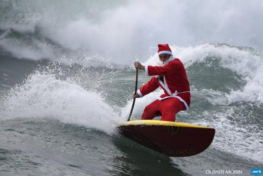 Babbo Natale fa surf cavalca le onde