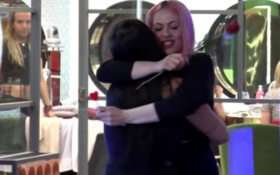 Elettra entrega una rosa a Daniela, bajo la vigilancia de Aless Gibaja