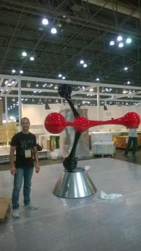 Artist Iftah Geva standing beside one of his masterpieces. / Image via Iftah Geva and Agora Gallery, used with permission.