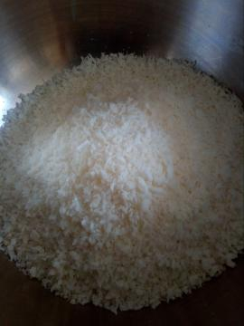Versa il cocco grattuggiato in un recipiente.