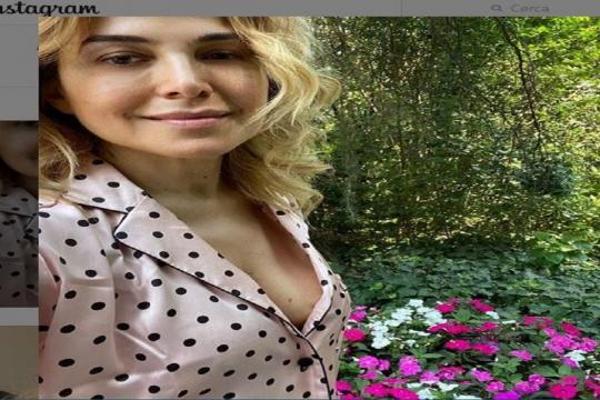 Barbara D'Urso attorniata da piante e fiori.